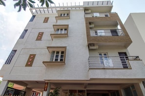 Un edifici de diverses plantes amb balcons, finestres i aparells d'aire condicionat.