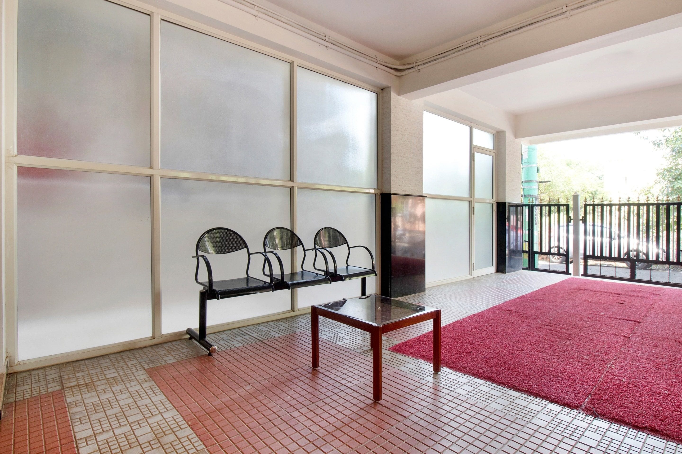 Un área de espera con un banco, una mesa y una alfombra roja.