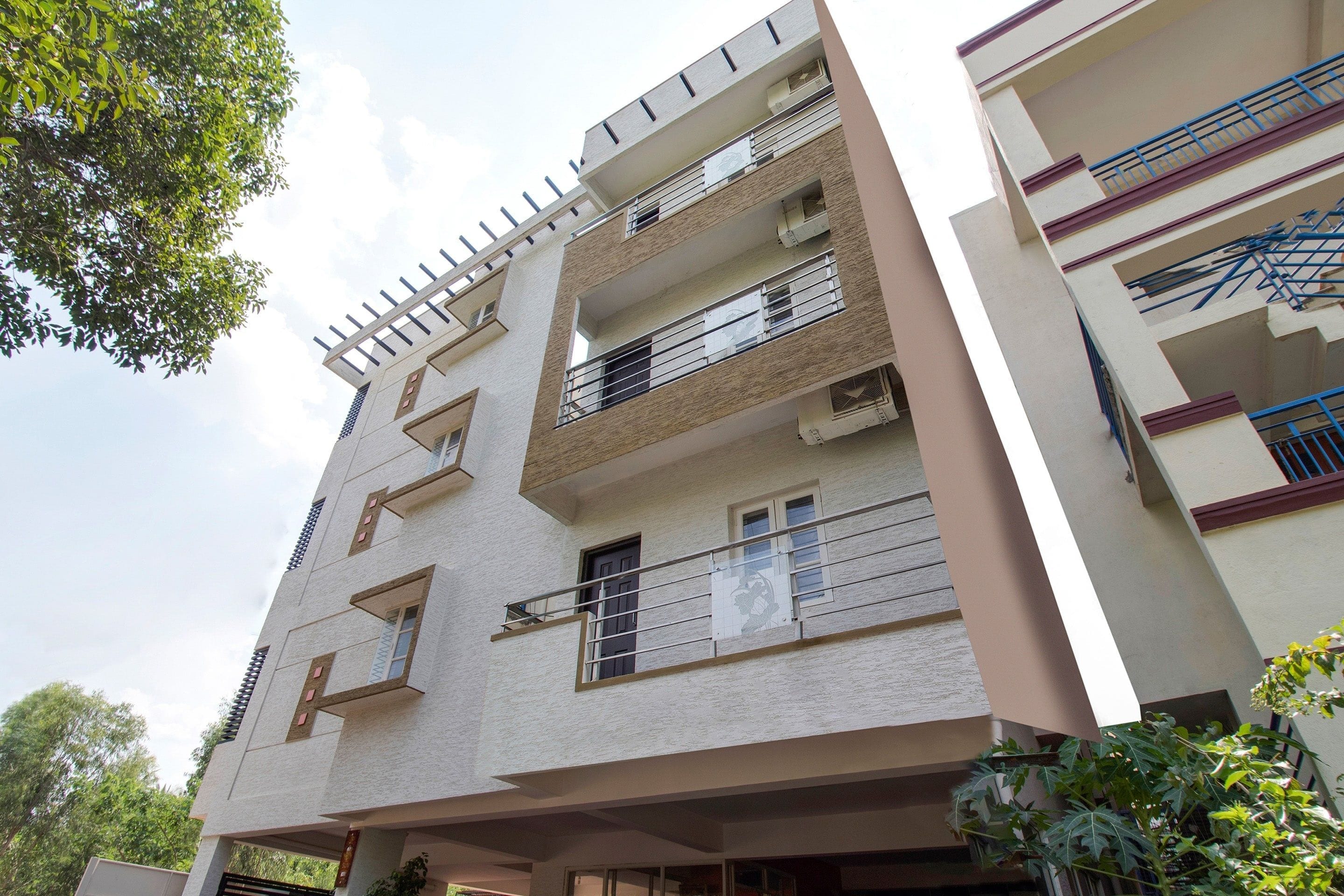 Un edificio residencial de varios pisos con balcones, ventanas y techo plano.