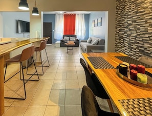 A modern living space with a kitchen area, dining table, and seating arrangements. - Newly renovated one-bedroom, one-bath ground unit at Turquoise Condominiums (Playas Del Coco)