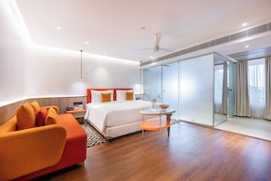 Una habitación de hotel moderna con cama, escritorio, silla, una mesita y una puerta corredera.