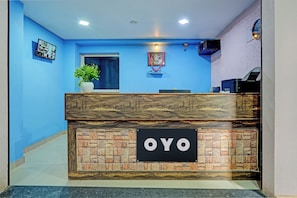 Una recepción con un cartel que dice 'OYO' en el vestíbulo de un hotel.