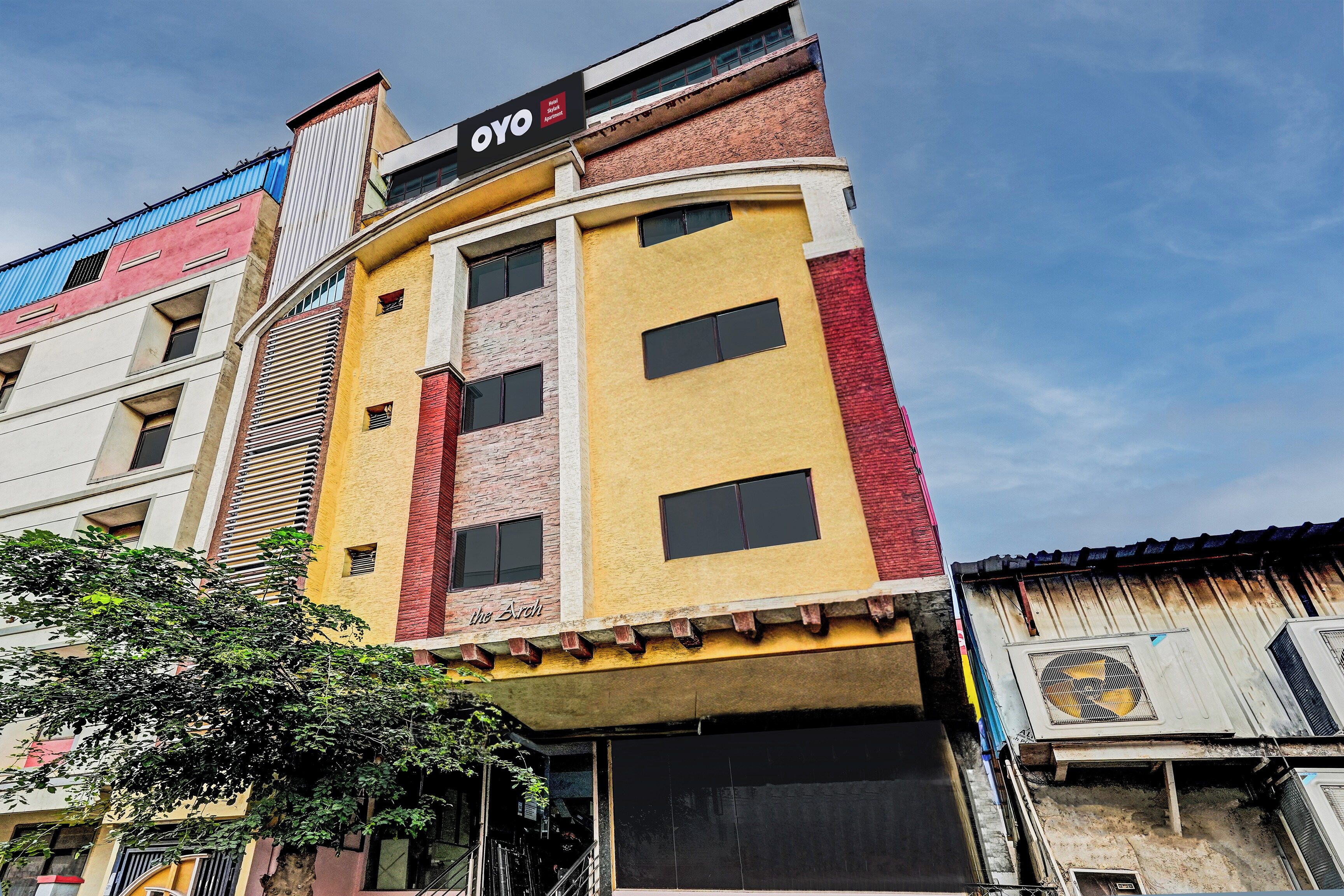 Un edificio de varios pisos con un letrero que dice 'OYO Hotel Skylark Apartment'.