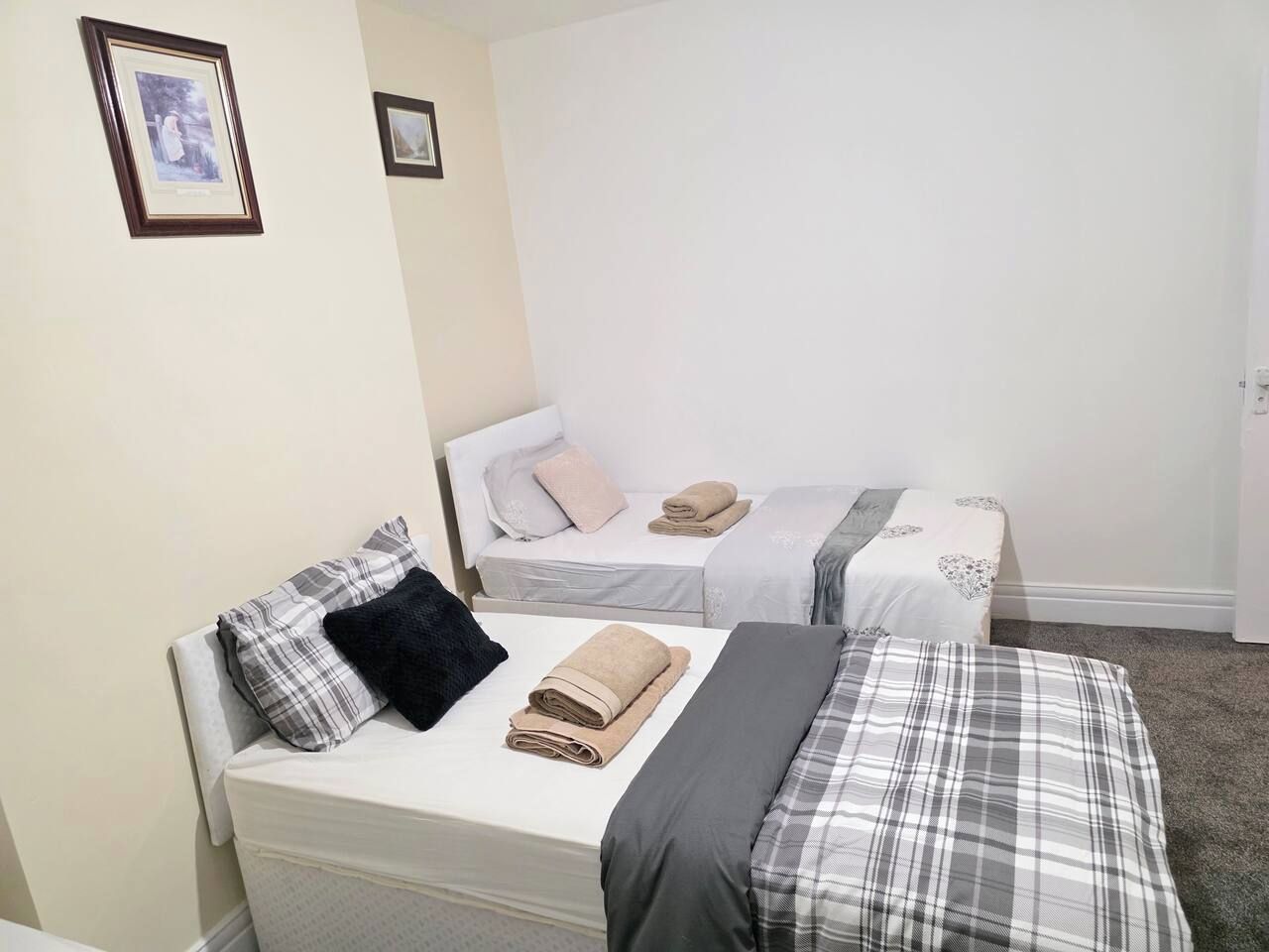 Une chambre avec deux lits, chacun étant équipé d’un oreiller et d’une serviette enroulée.