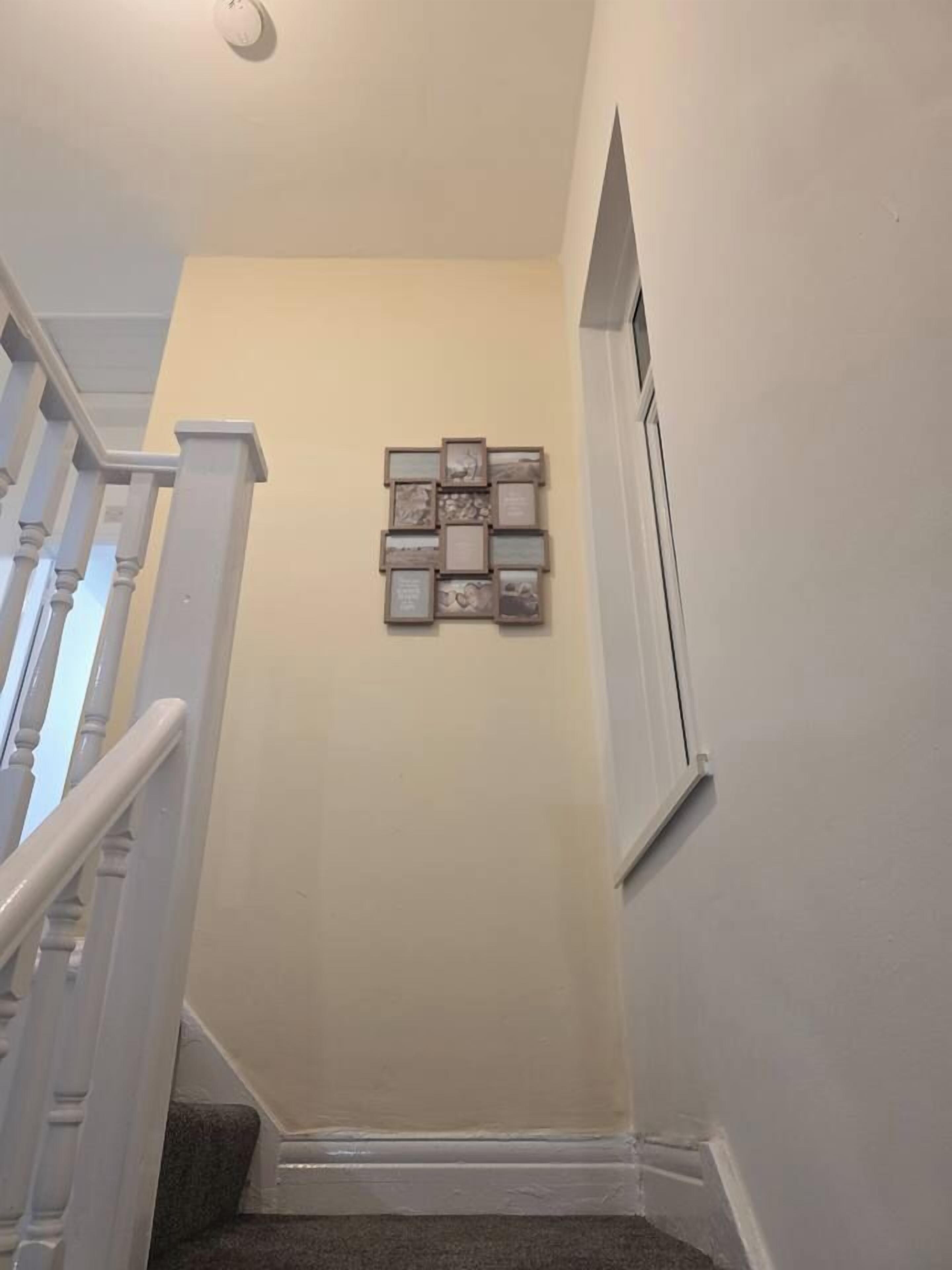 A staircase with a handrail and a wall-mounted picture frame.