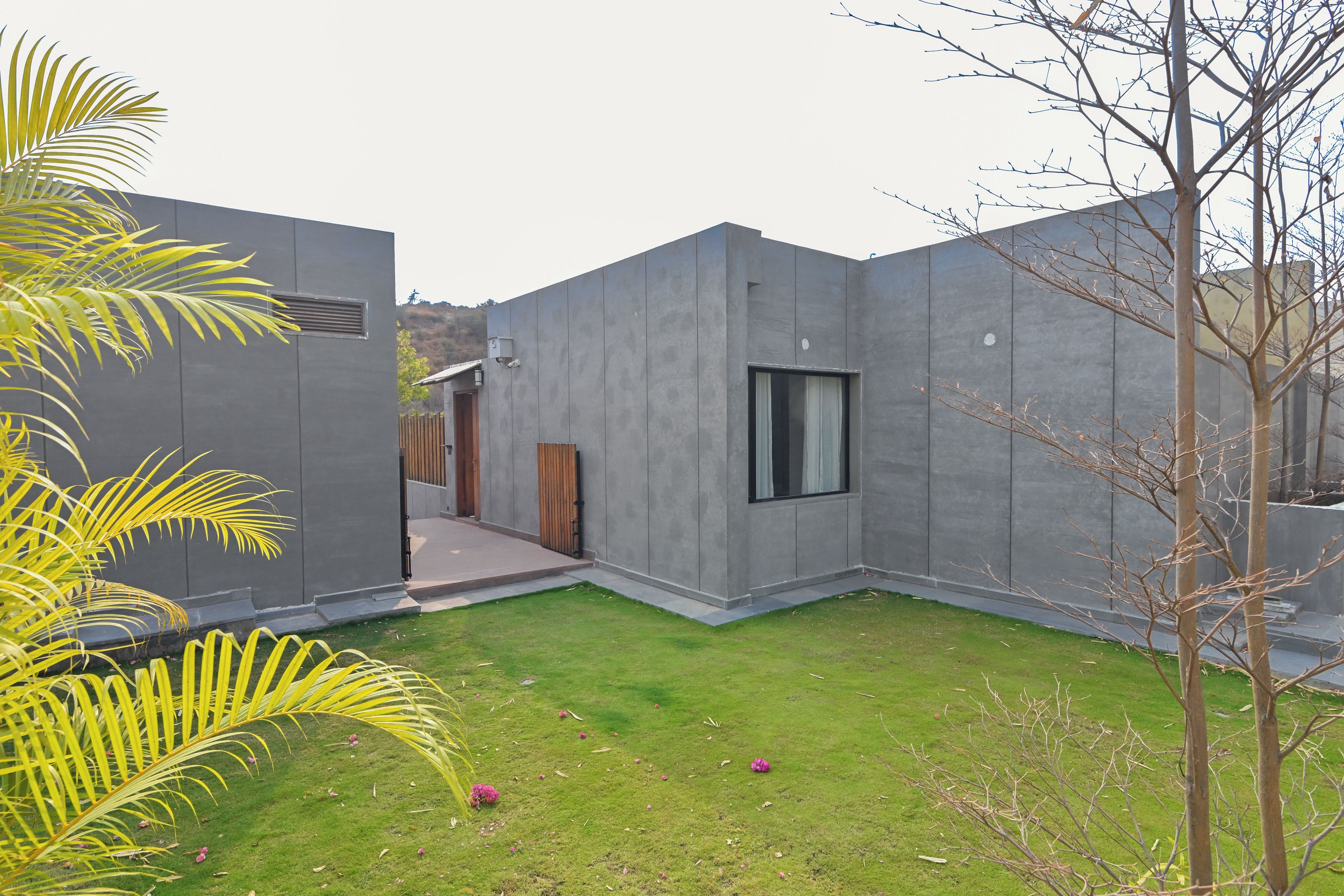 Un edificio moderno con techo plano, una ventana pequeña y una puerta.