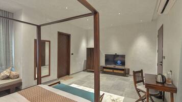 Una habitación de hotel moderna con cama con dosel, televisión, mesa de comedor con una silla y un espejo grande.