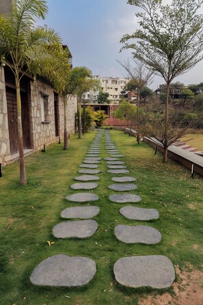 Uma trilha com degraus de pedra circulares que levam a um edifício com fachada de pedra.