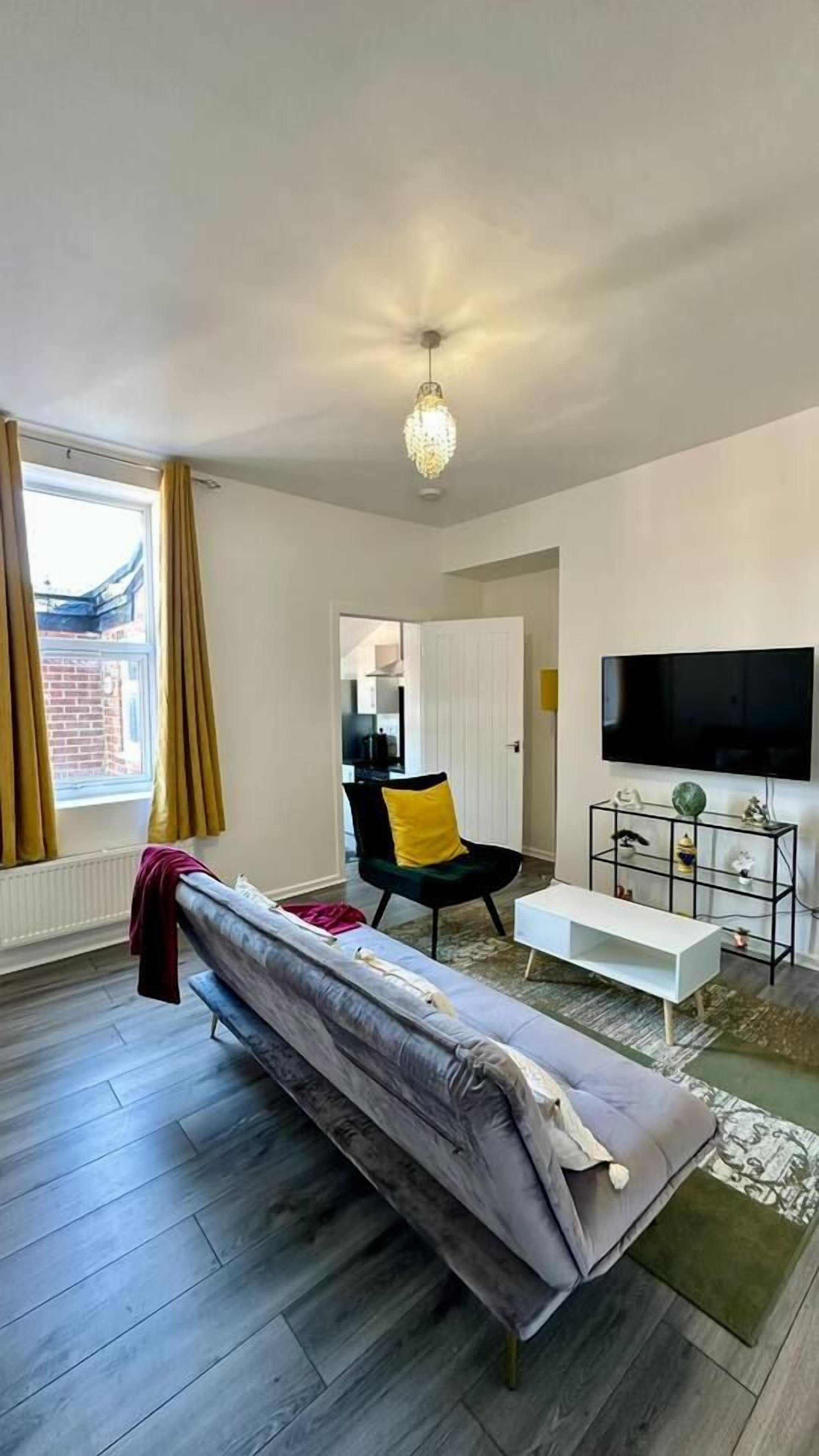 A modern living room with a sofa, a television, and a coffee table.