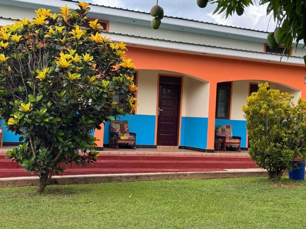 A building with a red and blue facade, a front door, and a small porch area.