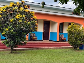 A building with a red and blue facade, a front door, and a small porch area.