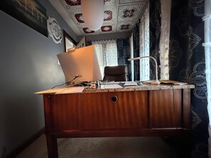 Ein Holztisch mit einem Computer, Papieren und einer Lampe.