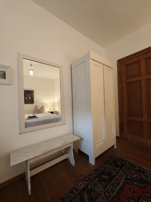 Habitació amb una banca, un armari i una porta.