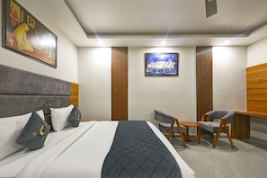 A modern hotel room with a large bed, a desk, a chair, and artwork on the walls. - Hotel Namaste Delhi Airport (New Delhi)