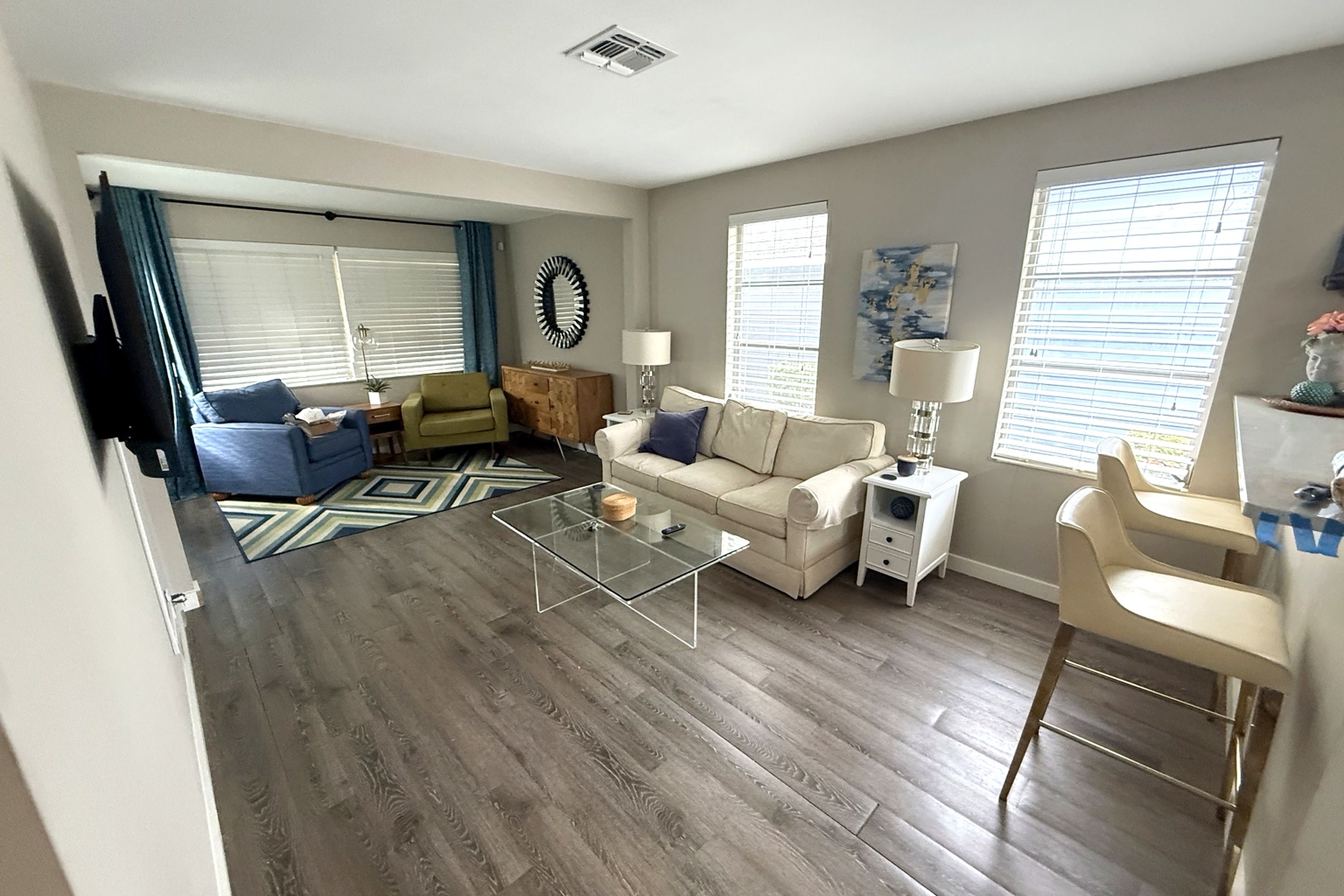 Bright sunroom with large windows, comfortable seating and plenty of natural light.
