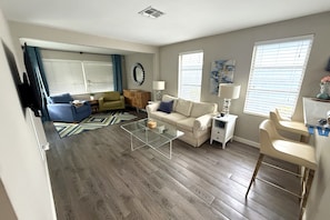 Bright sunroom with large windows, comfortable seating and plenty of natural light. - Tipsy Tangerine Cottage | 2BR Near Madeira Beach (St. Petersburg)