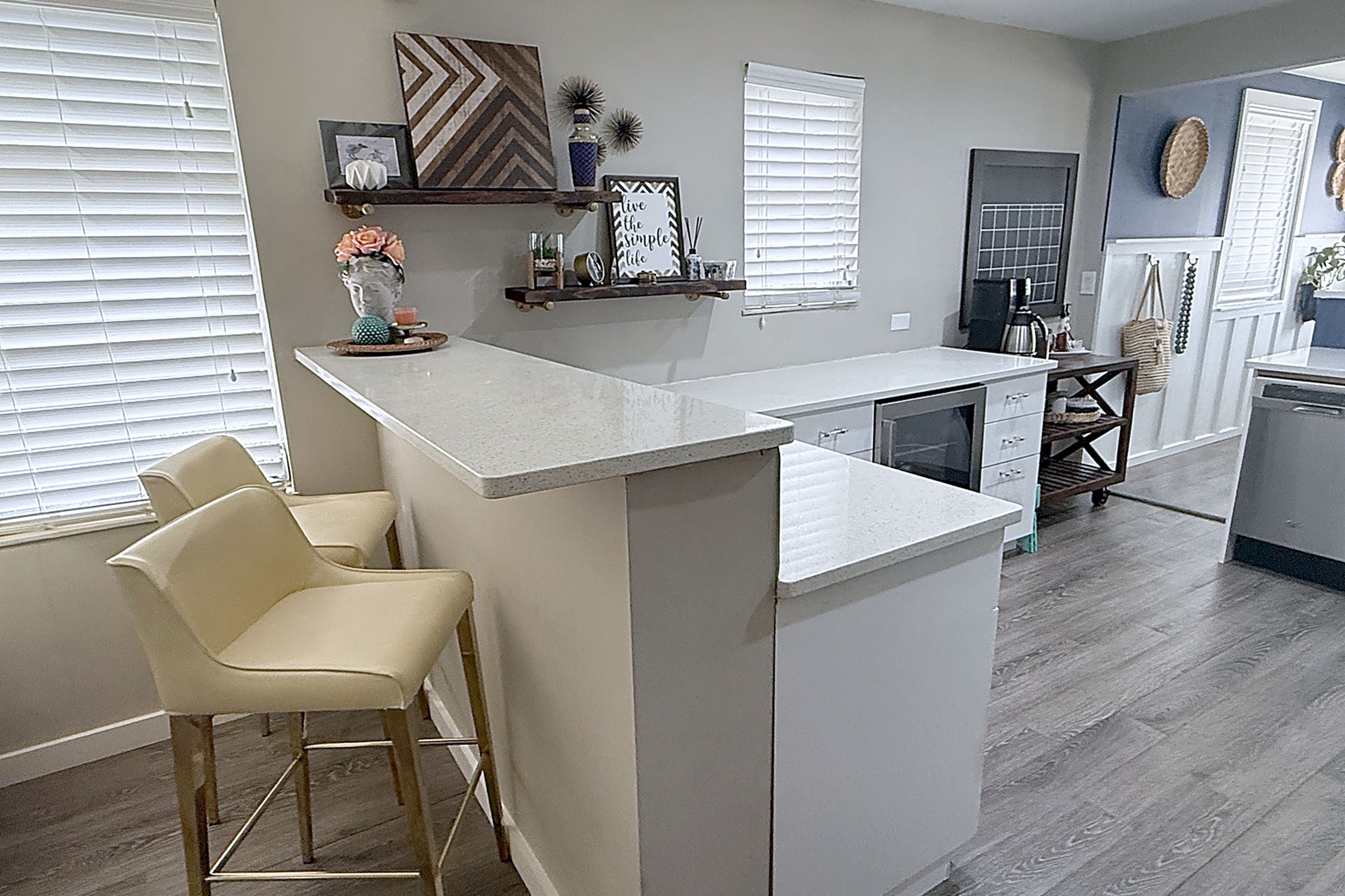 A modern kitchen with a central island, bar stools, and a built-in oven.