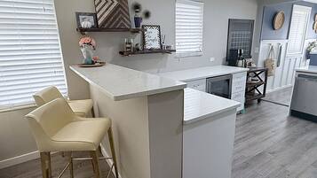 A modern kitchen with a central island, bar stools, and a built-in oven.