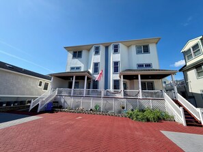 A multi-story building with a covered porch and a flagpole. - Ultimate Family Shore Getaway | 5BR Townhome Sleeps 12 in North Wildwood (North Wildwood)