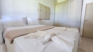 Ein Hotelzimmer mit einem Doppelbett, einem Nachttisch, einem Kleiderschrank und einem Spiegel.