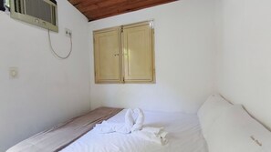 Una habitación con una cama, techo de madera y aire acondicionado de pared.