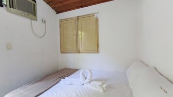 Una stanza con un letto, un soffitto in legno e un condizionatore d'aria a parete.