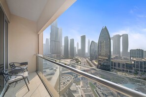A balcony with a glass railing overlooking a cityscape with modern skyscrapers. - Elegant Studio Downtown Dubai (dubai)
