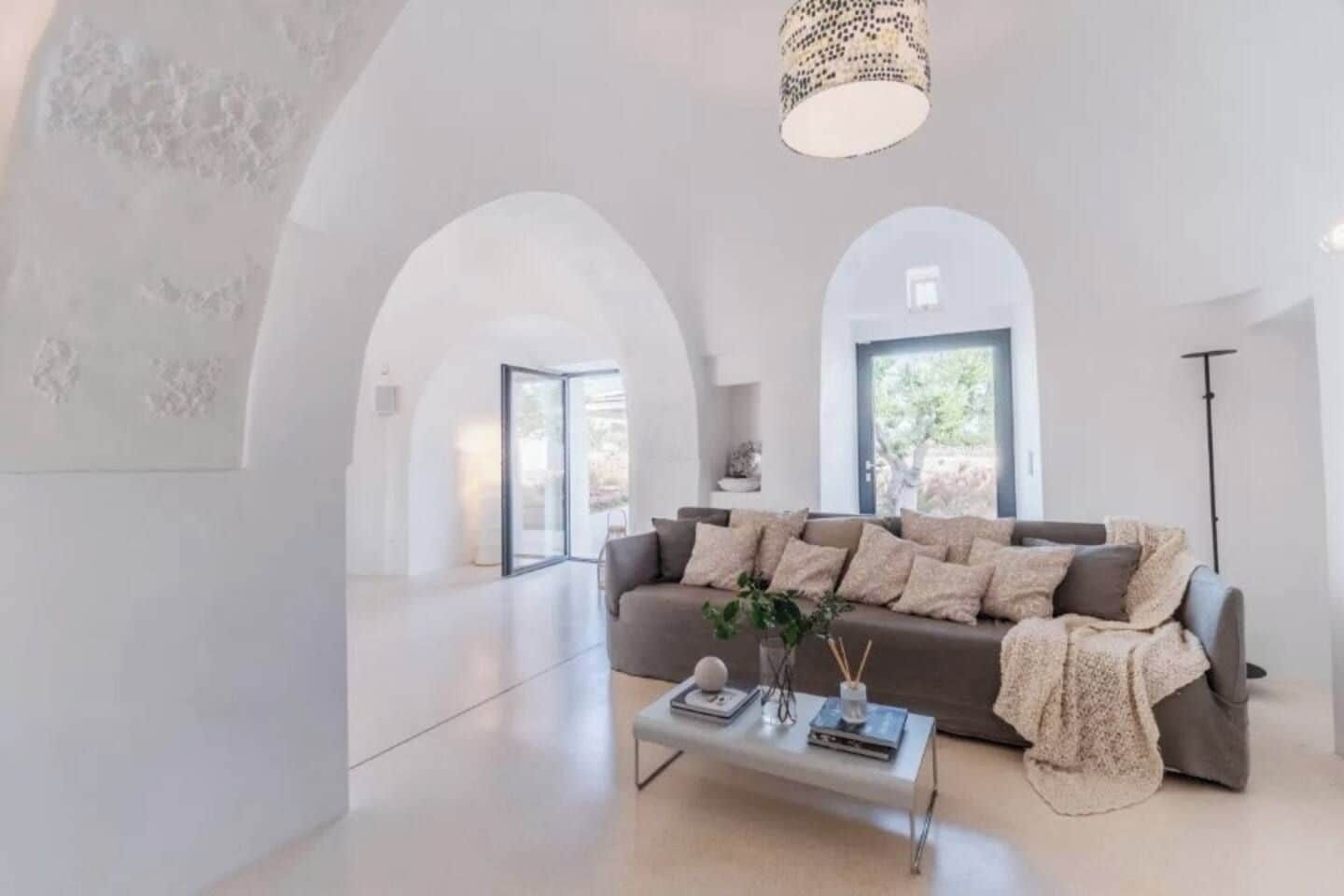 Un salon moderne avec un canapé, une table basse et une suspension.
