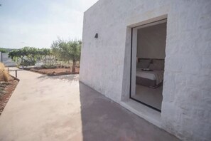 Ein modernes Gebäude mit einem Betonweg, der zu einem Zimmer mit einem Bett führt.