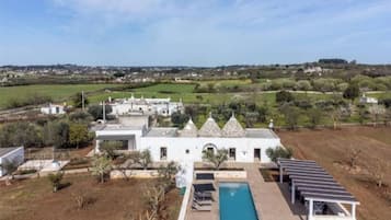 Un grand bâtiment blanc doté d’une piscine et de panneaux solaires.
