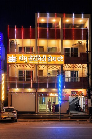 Un edifici de diversos pisos amb un senyal que diu 'Shri Ram Shree Hotel' i un cartell de 'BENVINGUT' a l'entrada.