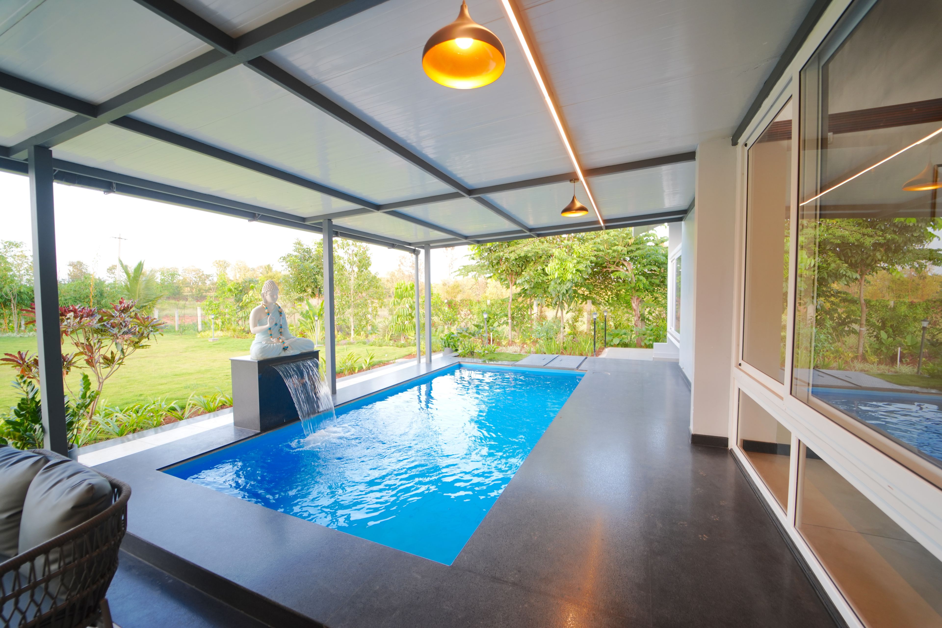 A modern indoor swimming pool with a clear view of the surrounding greenery.