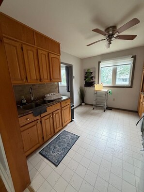 A kitchen with wooden cabinets, a built-in oven, a sink, and a ceiling fan. - Welcome home ! 
West end of Halifax, 3 bedroom home is waiting for you! (Halifax)