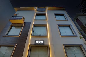 Un edificio moderno con numerosas ventanas y un llamativo letrero 'OYO'.