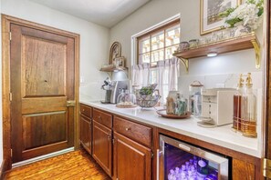 Una cocina con armarios de madera, un refrigerador empotrado y diversos electrodomésticos.