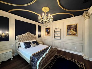 Una camera da letto lussuosa con un letto grande, soffitto decorato e raffinate decorazioni alle pareti.