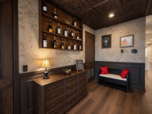 A bar area with wooden shelves displaying bottles, a bench with red cushions, and a wall with framed artwork. - Ever After Estate | Luxury 12 Bed Home | 9 mins to Disney World (Kissimmee)