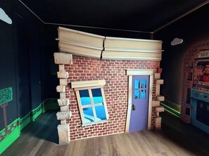 Una stanza con una parete in mattoni, una finestra e una porta.