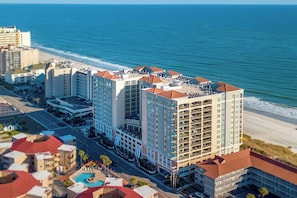 A high-rise hotel with multiple floors, a rooftop pool, and a view of the beach. - Elegant Oceanfront Condo, Indoor and Outdoor Pools | Mar Vista Grande - 1511 (North Myrtle Beach)