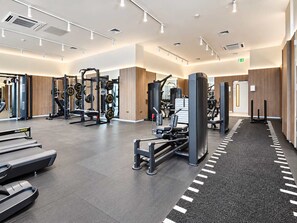 Un gimnasio moderno con diversos equipos de ejercicio, incluyendo máquinas de pesas y cintas de correr.