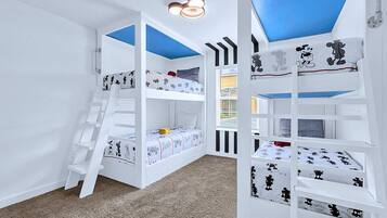 A children's bunk bed room with a ladder, white walls, and a window with blinds.