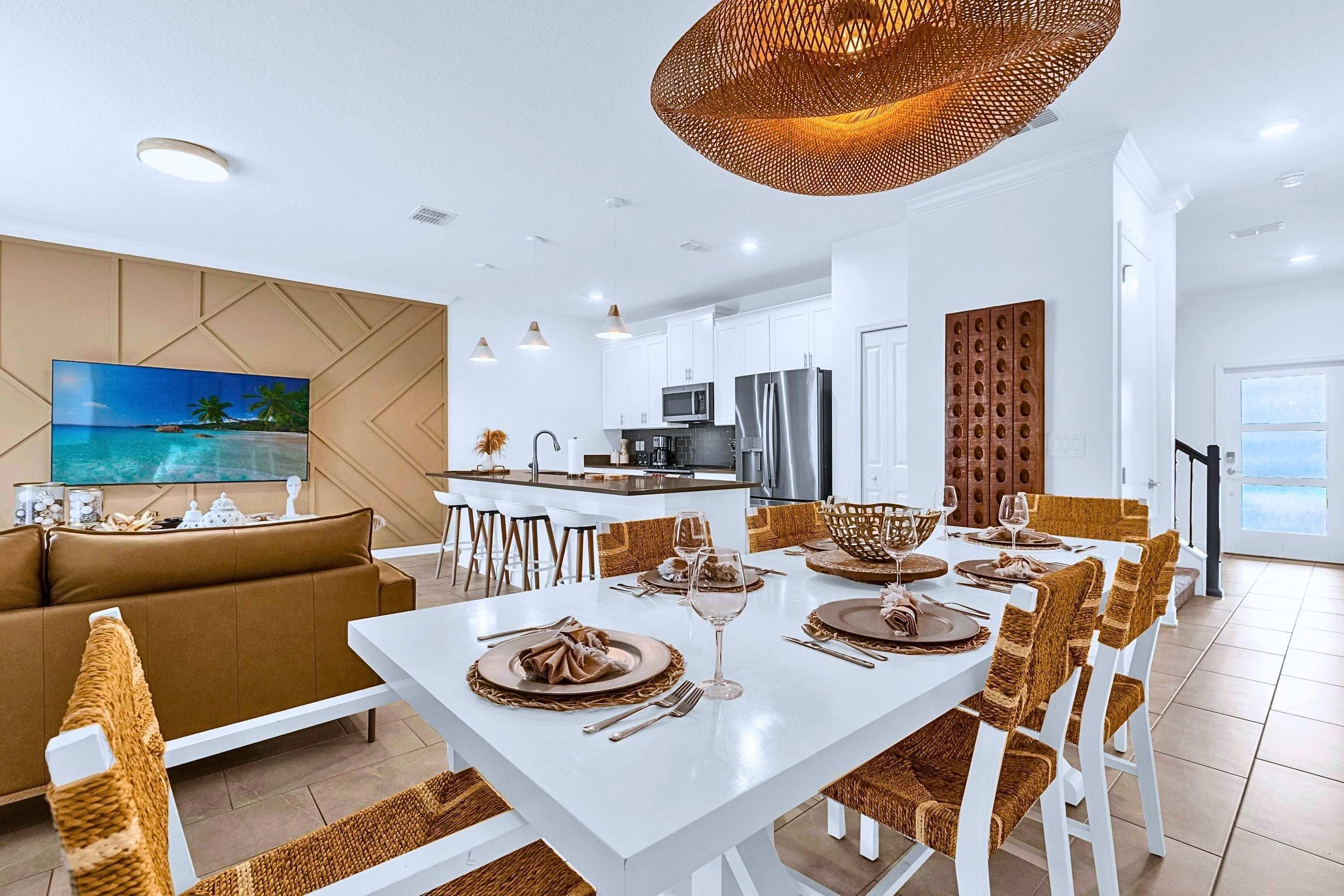 A modern living room with a sofa, dining table set for six, and a kitchen in the background.