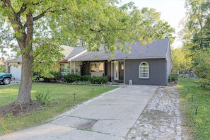 A residential house with a front porch, a driveway, and a stone pathway leading to the entrance. - Indianapolis Escape, Easy Access to Dtwn! (Indianapolis)