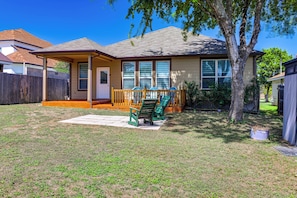 A residential house with a covered patio, a fenced yard, and a tree. - Fenced Yard & Playset Near SA Airport & Parks (San Antonio)