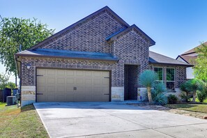 A residential house with a brick facade, a garage, and a well-maintained lawn. - Fenced Yard & Playset Near SA Airport & Parks (San Antonio)