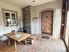 Un interior rústico con una mesa de madera, un banco y una chimenea de piedra.