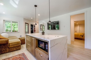 A modern kitchen with a marble countertop, built-in oven, and pendant lighting. - Snohomish Executive Suite w/ Deck & Fire Pit (Snohomish)