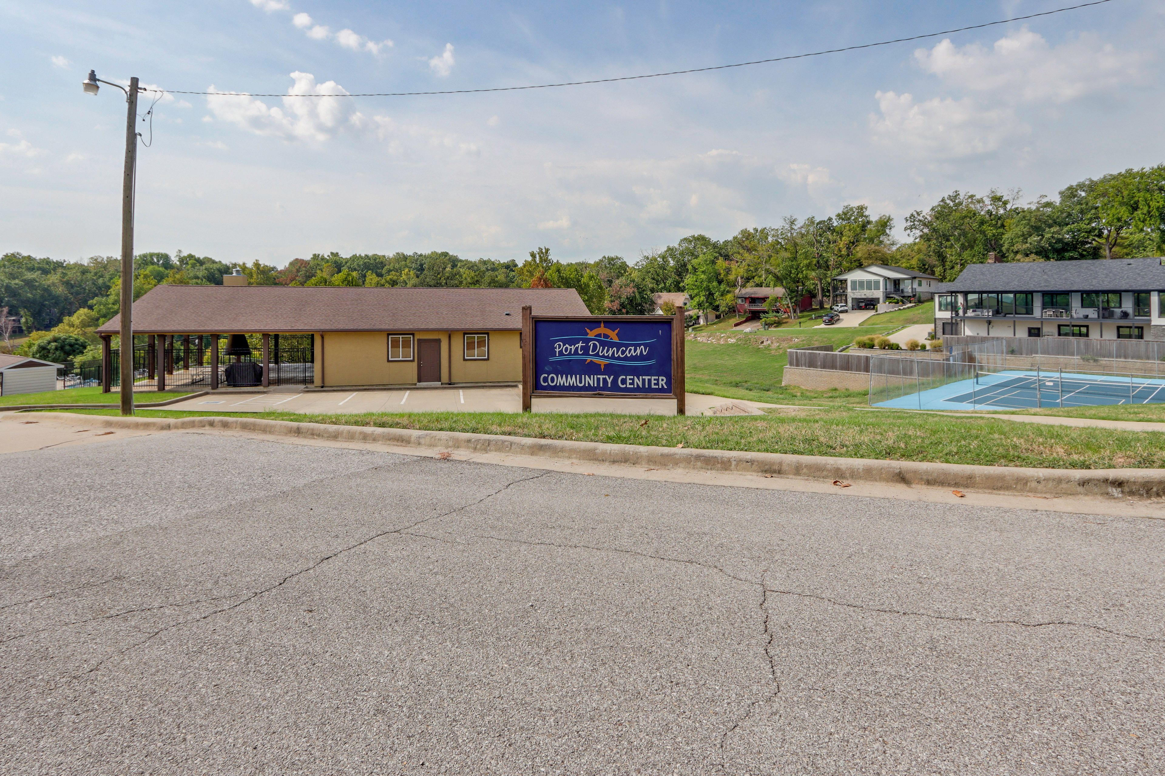 A community center with a sign, a covered outdoor area, and a pool.