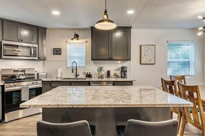 A modern kitchen with granite countertops, stainless steel appliances, and a central island with seating. - Grand Lake Golf Getaway Near Shangri-la, Game Room (Afton)