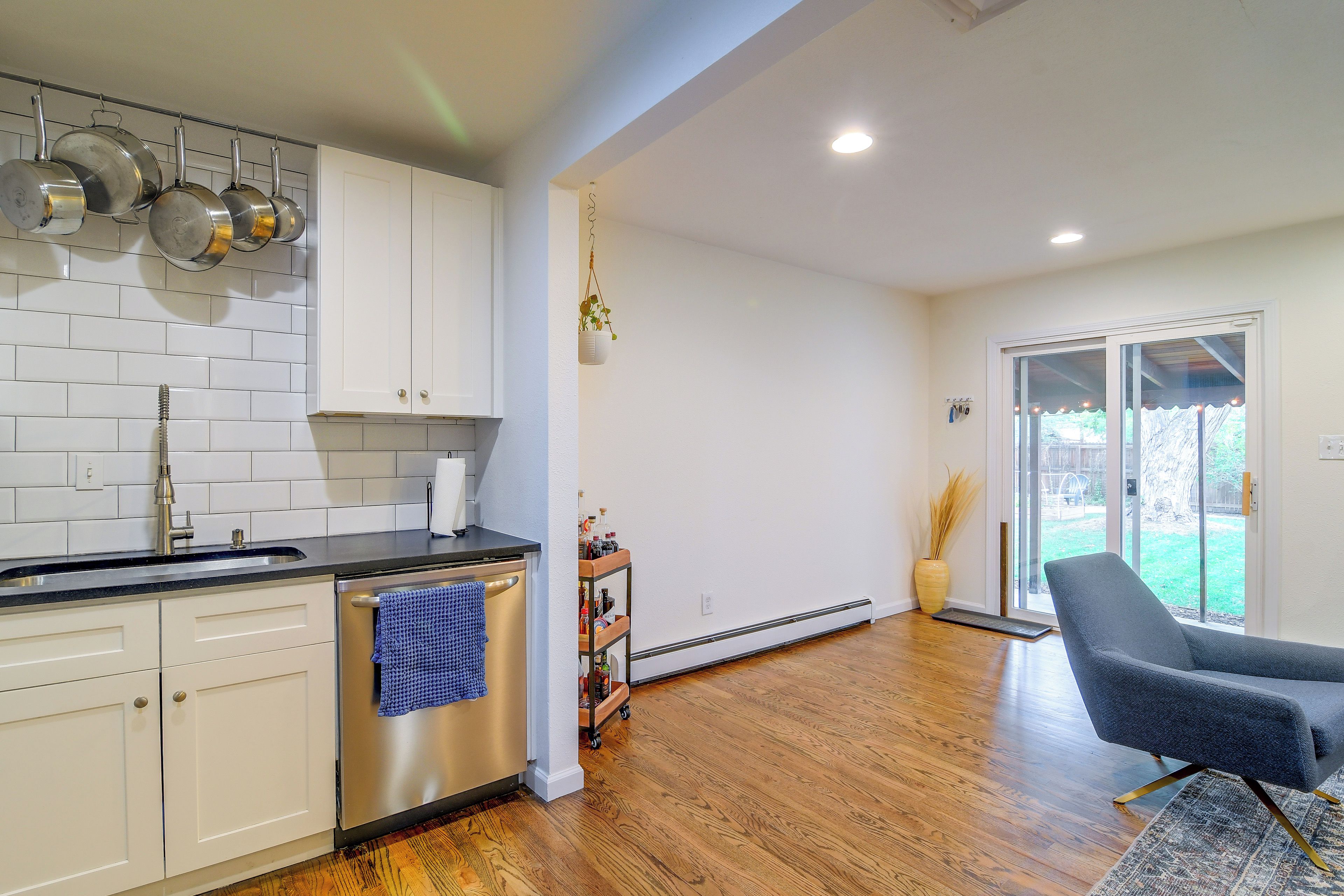 A modern kitchen with white cabinets, stainless steel appliances, and a black countertop.